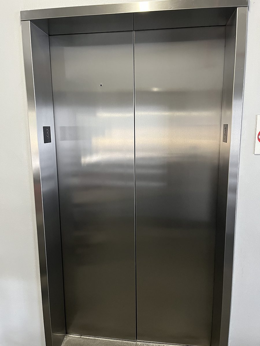 Stainless steel entrance with an even, directional brushed grain