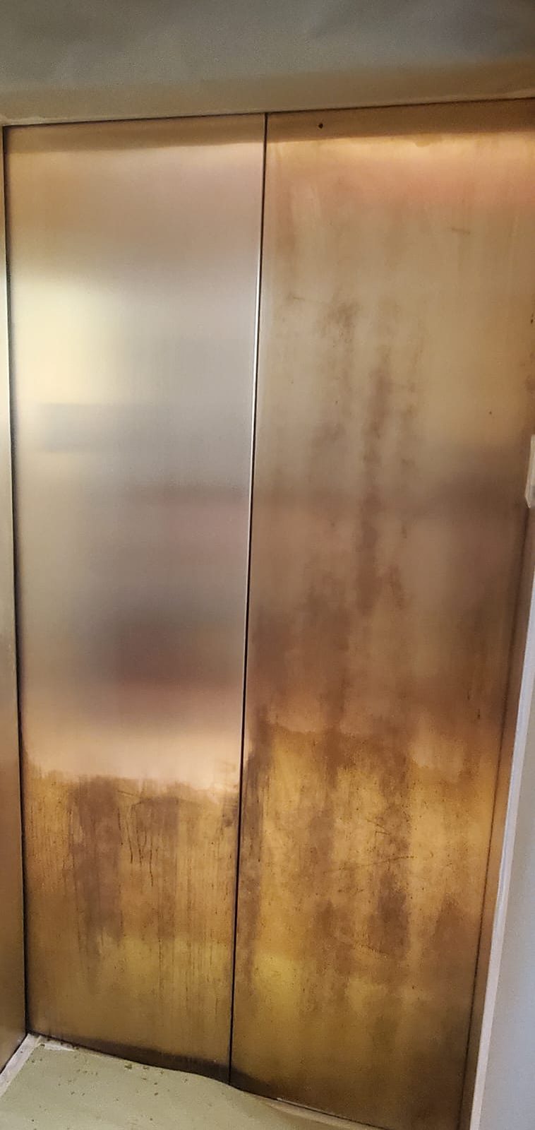 Bronze doors as we found them, with heavy oxidation and staining